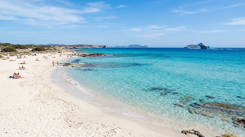 The long white sandbar beach of Formentera with a wooden walkway crossing low dunes